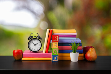 Stack of books on wooden table against blurred background