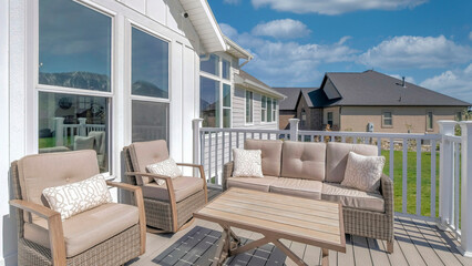 Panorama White puffy clouds Outdoor patio on a wooden deck with cushioned woven sofa and arm