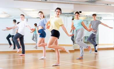 Fototapeta na wymiar Positive teenagers are dancing hip hop in dance studio