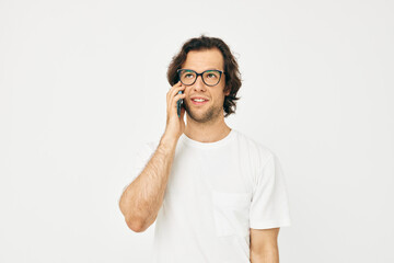 Cheerful man in a white T-shirt communication by phone isolated background