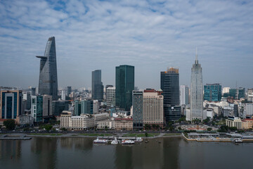 Fototapeta na wymiar Drone panorama view of Ho Chi Minh City center featuring skyline and newly completed waterfront redevelopment along the Saigon river on sunny morning.