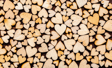 Wooden hearts as a background. The texture of figurines in the form of hearts as a romantic background from natural materials. Love
