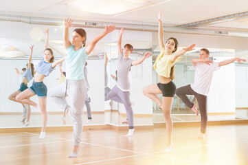 Fototapeta na wymiar Positive teenage dancers doing dance workout during group class