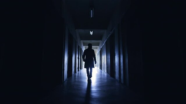 The man walking through the dark corridor