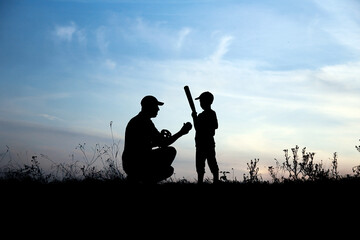 silhouette of father and son playing baseball on nature family sport