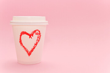 Takeaway coffee cup, paper cup with red shape of heart on pink background
