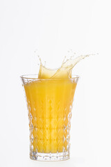 Fototapeta na wymiar Close up of a glass with splashing orange juice