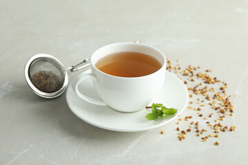 Concept of hot drink with buckwheat tea on light textured background