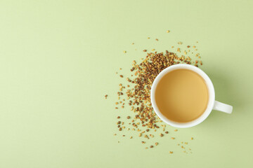Concept of hot drink with buckwheat tea on green background