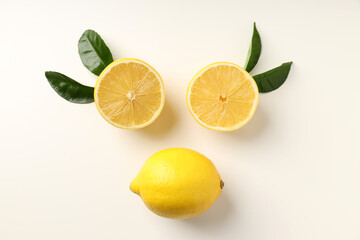 Lemons and leaves on white background, top view
