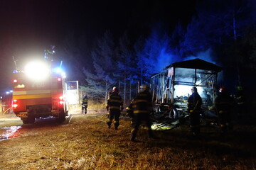 caravan fire at night. Firefighters at night destroy a large caravan fire in the woods