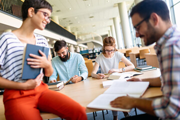 Happy group of students studying and working together in a college library