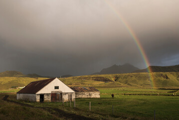 Typical Icelandic farm buildings under a rainbow by the Dyrholaey Peninsula, near Vik, South Iceland (Sudurland), Europe