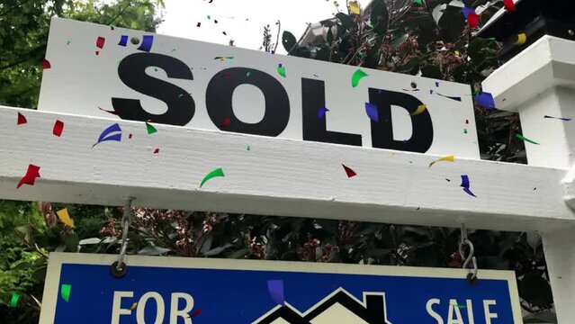 SOLD! Celebrating the purchase of a new home. Colorful confetti dropping from sky.