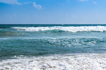 Fototapeta na wymiar Waves with foam roll on the shore