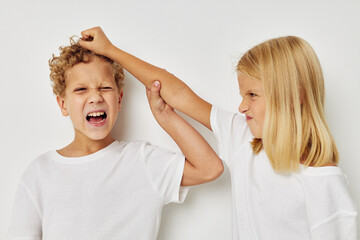 Photo of two children in white T-shirts are standing next to childhood unaltered