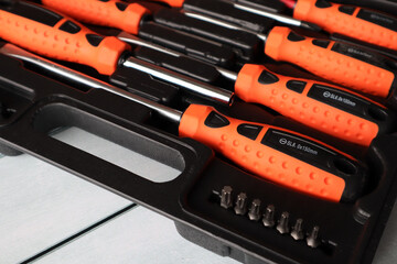 A set of screwdrivers with various attachments in a black suitcase for storage.