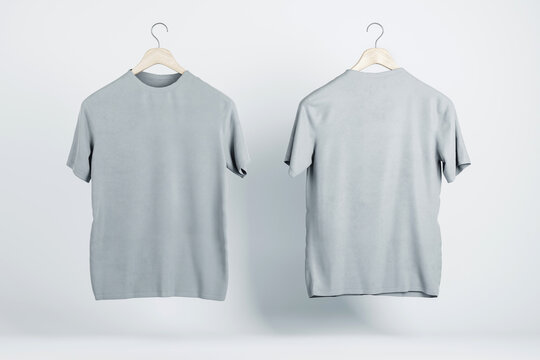 Two blank grey t-shirts hanging in the air with copyspace for your logo on abstract light background. 3D rendering, mockup