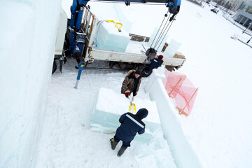 Workers unloading ice blocks from a car
