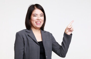 Portrait studio isolated cutout closeup shot of Asian young happy professional successful female businesswoman in formal suit jacket smiling look at camera holding hand pointing on white background