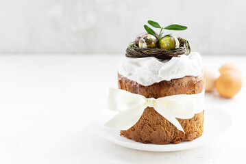 Easter cake with chocolate eggs in a nest on a light background. Horizontal orientation, copy space.