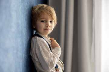 Cute portirait of blond preschool child, boy, on blue background