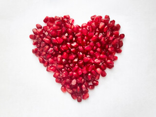 Heart from pomegranate seeds isolated on white background. Heart shape.