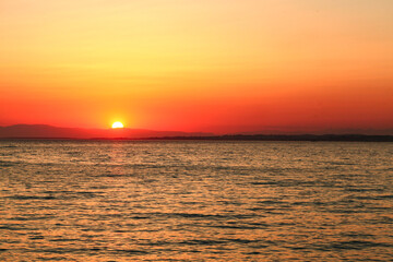 Sunset by the sea, the sky is reflected in the sea