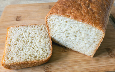 Cut a loaf of white bread with a slice