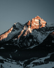 Scenic view in snowy mountains  and beautiful nature at sunrise with orange and blue tones.