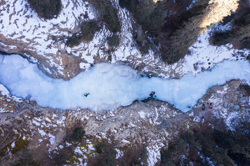 Mountaineer Man is leading on Ice. Ice Climbing on Frozen Waterfall, Aerial Top-Down View. Barskoon...