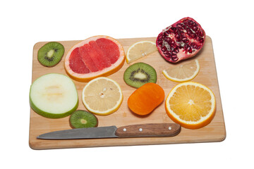 Fruit concept. Cut the fruit into slices. Garnet. grapefruit. kiwi. pear. buckwheat. orange. lemon. raisins. cinnamon stick. table-knife. on a wooden background
