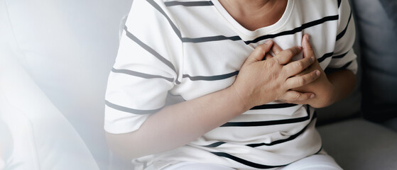 Closeup of asian woman having heart attack. Woman touching breast and having chest pain. Healthcare And Medical concept..
