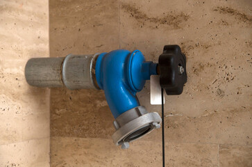 Blue fire hydrant and a house wall close