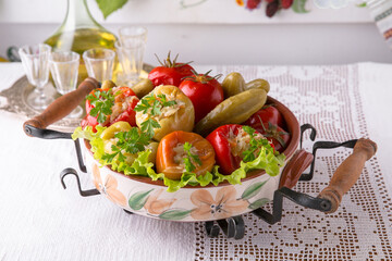 Delicious homemade pickles: peppers stuffed with cabbage, tomatoes, cucumbers. National Moldavian, Romanian, or Ukrainian cuisine. Traditional dishes in an authentic interior.