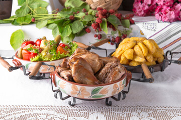 Homemade fried potato slices, assorted pickles, rabbit stewed in the oven. National Moldavian, Romanian, or Ukrainian cuisine. Traditional dishes in an authentic interior.