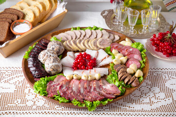 Cold cuts from homemade sausages, bacon, meat snacks, pastrami. National Moldavian, Romanian, or Ukrainian cuisine. Traditional dishes in an authentic interior.