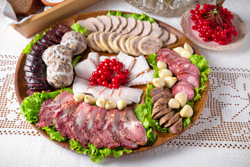 Cold cuts from homemade sausages, bacon, meat snacks, pastrami. National Moldavian, Romanian, or Ukrainian cuisine. Traditional dishes in an authentic interior.