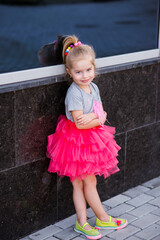 Little girl child wearing a pink skirt outdoors having fun
