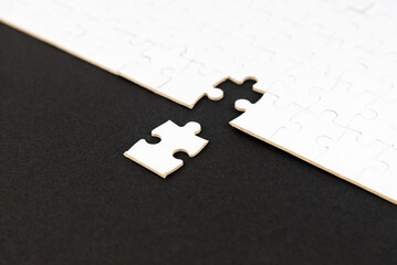 White puzzle with missing piece on black background. Business concept. Finish what you start. Team...