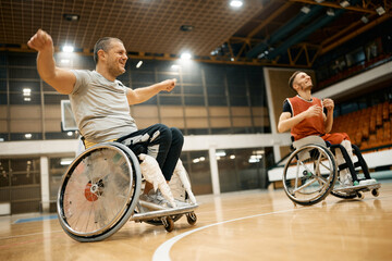 Happy basketball player in wheelchair has fun while while warming up with his teammates for sports training.