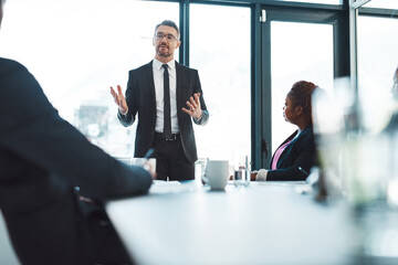 Fototapeta premium Giving a thoroughly detailed presentation. Cropped shot of a handsome mature businessman giving a presentation in the boardroom.