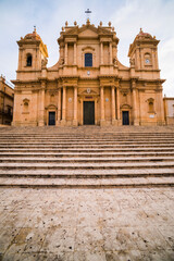 Obraz premium Noto, St Nicholas Cathedral (Duomo, Cattedrale di Noto), seen from the impressive steps of the Baroque building in the UNESCO World Heritage Listed town of Noto, Sicily, Italy, Europe