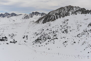 Fototapeta na wymiar Pyrenees mountains range in winter with snowy peaks in Grandvalira ski paradise resort in Andorra