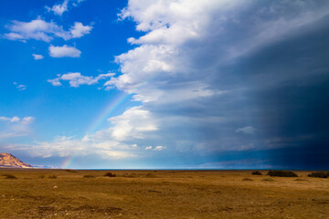 Fototapeta na wymiar Rainbow and storm clouds over the Dead Sea in Israel.