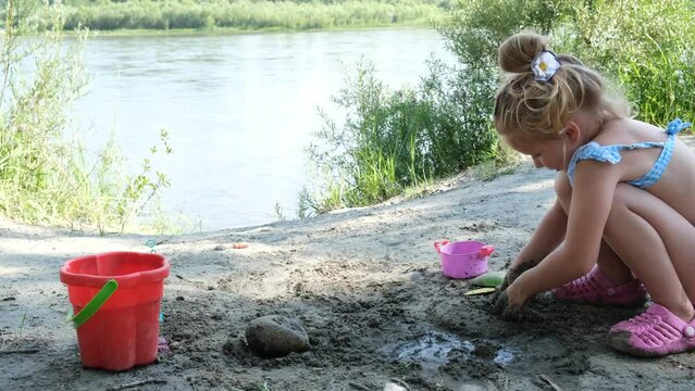 Child girl playing on the beach. Investigate  details of nature. outdoor kids activity and learning concept
