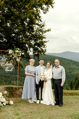 elderly parents with a young wedding couple after a wedding ceremony in the mountains