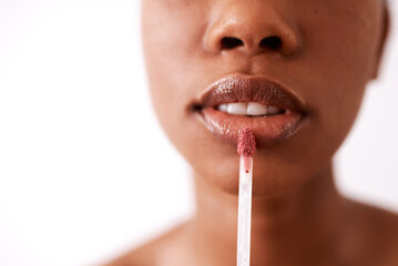 Naklejka premium Glossy lips will never go out of style. Studio shot of an unrecognizable woman applying gloss to her lips.