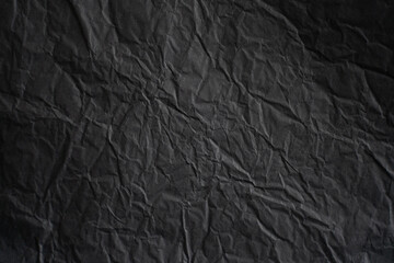 an empty wrinkled dark black tissue paper textured background
