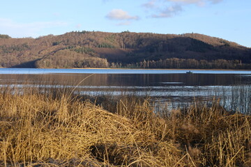 Maria Laach, Laacher See, Germany, February 2022, view of the lake just before sunset in beautiful sunlight and weather with blue sky